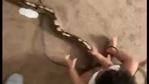 This kid playing with snake like its nothing soo brave