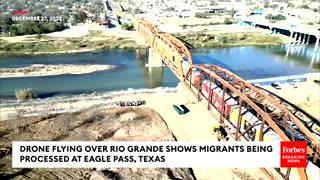 Drone Flying Over Rio Grande Shows Migrants Being Processed At Eagle Pass, Texas