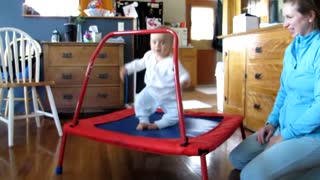 Adorable baby loves jumping on trampoline