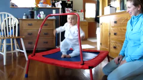 Adorable baby loves jumping on trampoline