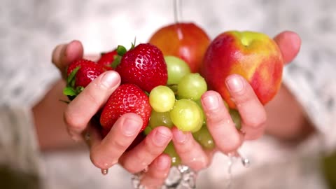 Rinsing strawberries apples and grapes holding hands