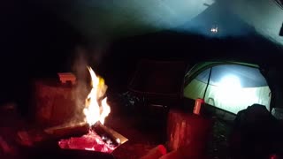 Setting up the camera to film a campfire vlog under the tarp.