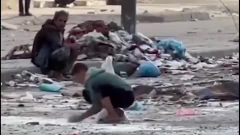 A group of children collecting flour from the ground in Gaza to make bread