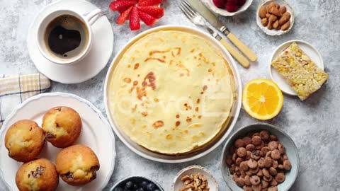 Breakfast table setting with fresh fruits pancakes coffee croissants