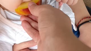 Baby eating peach