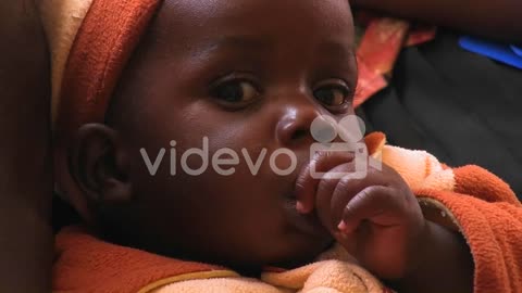 A baby girl sucking her thumb