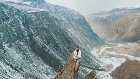 Woman Having a Phone Call while Sitting on a Peak