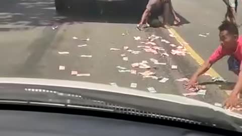 scattering money on the street makes residents commotion