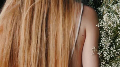 Woman with Long Hair Carrying Flowers