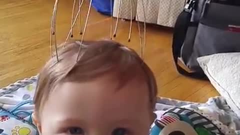 Baby has mind blown by scalp massager