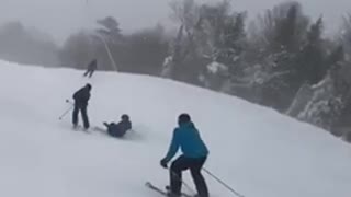 One person skiing runs into another person skiing