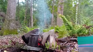 out on scout cooking supper with fire box stove