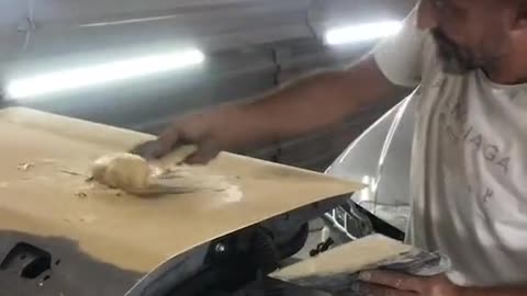 The mechanic repairs the sheet metal of the car