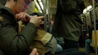 Guy quietly vogues and dances by himself on subway train