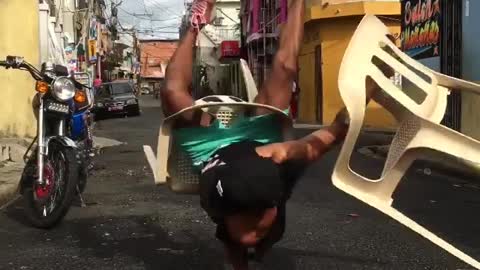 Check out this dude dancing on his hands with plastic chairs