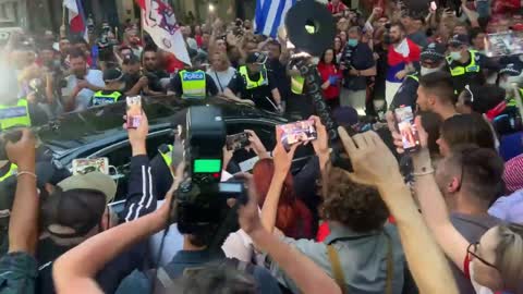 Large crowd chants "Novak, Novak, Novak," outside Novak Djokovic's lawyers office.