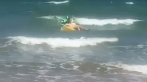 Guy floats in ocean on large pineapple inflatable toy