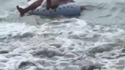 Man in swan floaty flipped in wave