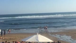 Two guys on sand beach fighting