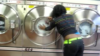 Woman Opens Washing Machine At Laundromat Mid-Cycle