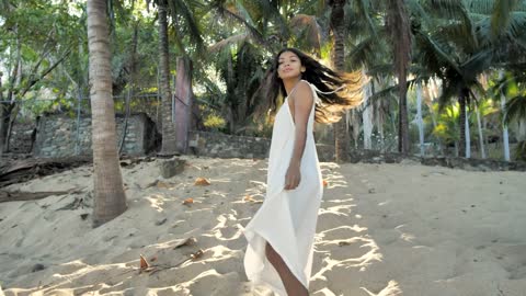 Woman walking among palm trees