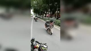 Man Riding Scooter In Heavy Traffic Lies Down For Cig