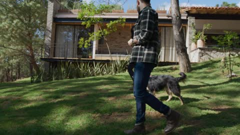 Man and woman walking a dog in a garden