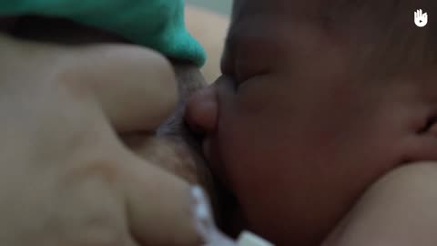 Feeding a baby with a cup of milk _ Breastfeeding