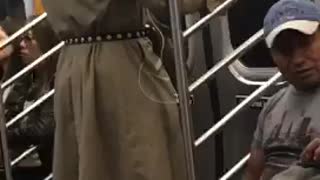 Man in brown trench coat dancing on subway