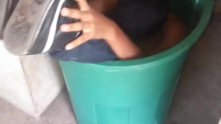 Boy stuck inside green basket tub