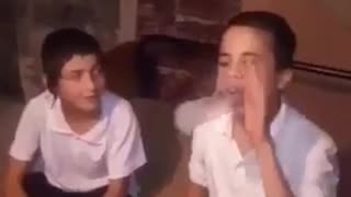 Two kids in uniform one slaps the other in the face