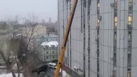Using a Crane to Place a Panstar Mobile SAM On Top of High Rise Building in Moscow