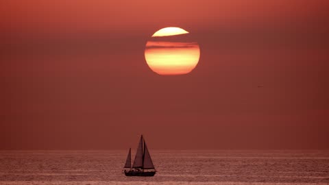 View of the horizon in the sea while a sailboat sails