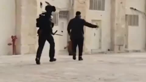 Palestinian child panics as Israeli troops attack his father in the courtyard of the Al-Aqsa Mosque