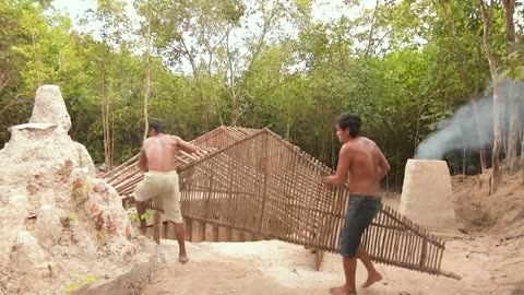 Building underground hut with grass roof & fireplace with clay