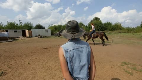 Horse riding's coach - cowgirl - teaching the girl for horseback riding at daytime - riding lesson