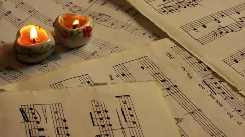 Heart candles on sheet music