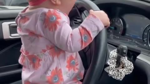 Cute baby trying to drive the car