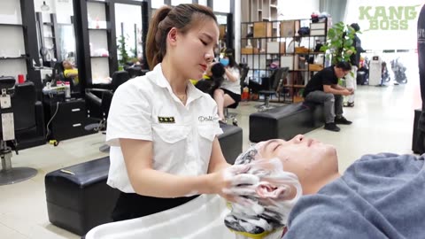 luxury men salon, a beautiful woman gives a scalp care massage service after a haircut