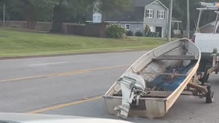 Precariously Placed Boat Falls Off Tire-less Trailer