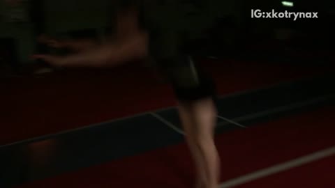 Girl back flip on red mat lands on back