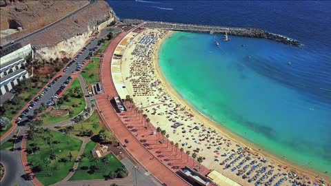 beautiful aerial view of playa de amadores bay with other cliffs on the seashore on