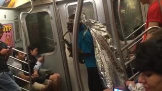 Guy blue shirt foil wings playing saxophone subway train man