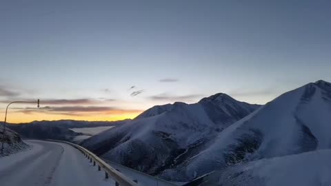 Watching the sunrise in the early morning in the snow-capped mountains of the plateau