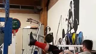 Guy in grey lifting weights falls back on other guy