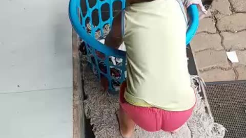 2 years baby helping her mother to dry his cloths