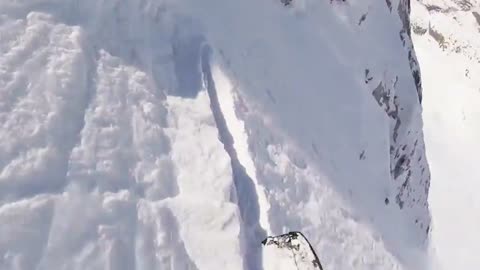 Snowboarder rolls down steep mountain after loosing traction