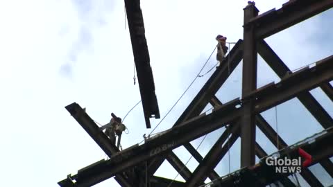 Construction worker seen dangling from crane in Toronto