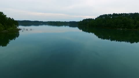 Drone Flying Over A Lake With A Smooth Surface