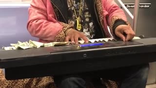 Performer on subway train plays the piano